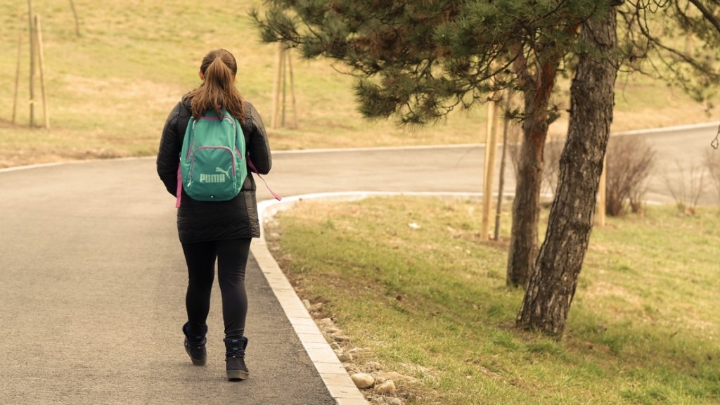 Ein Bild von einem Mädchen, das eine Straße antlangläuft.