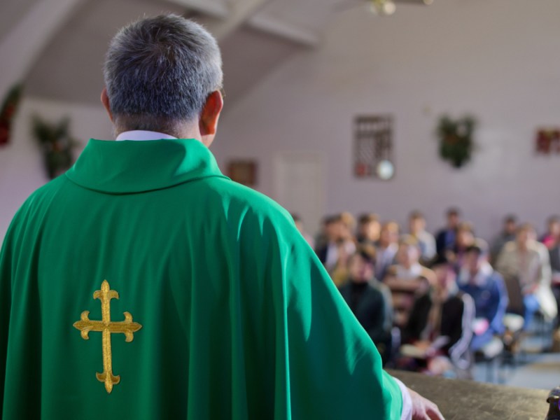 Ein Pfarrer hält eine Predigt in einer Kirche.