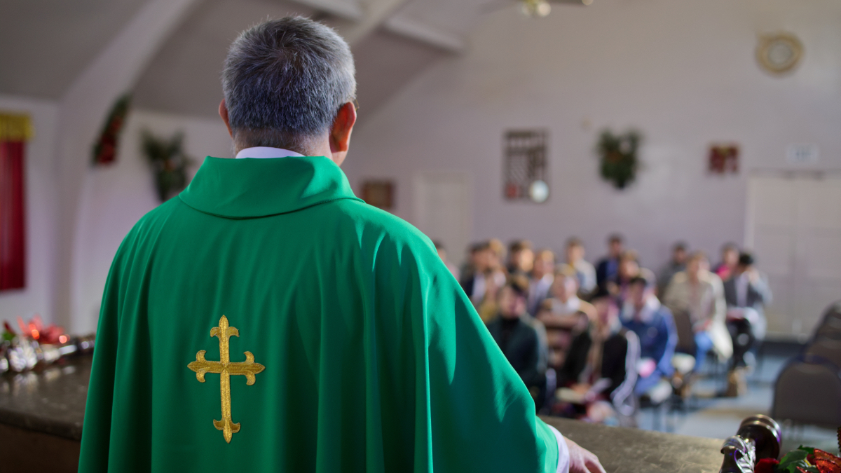 Ein Pfarrer hält eine Predigt in einer Kirche.