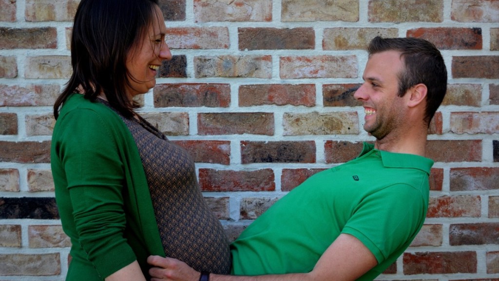 Eine schwangere Frau posiert mit ihrem Partner in einem lustigen Foto.