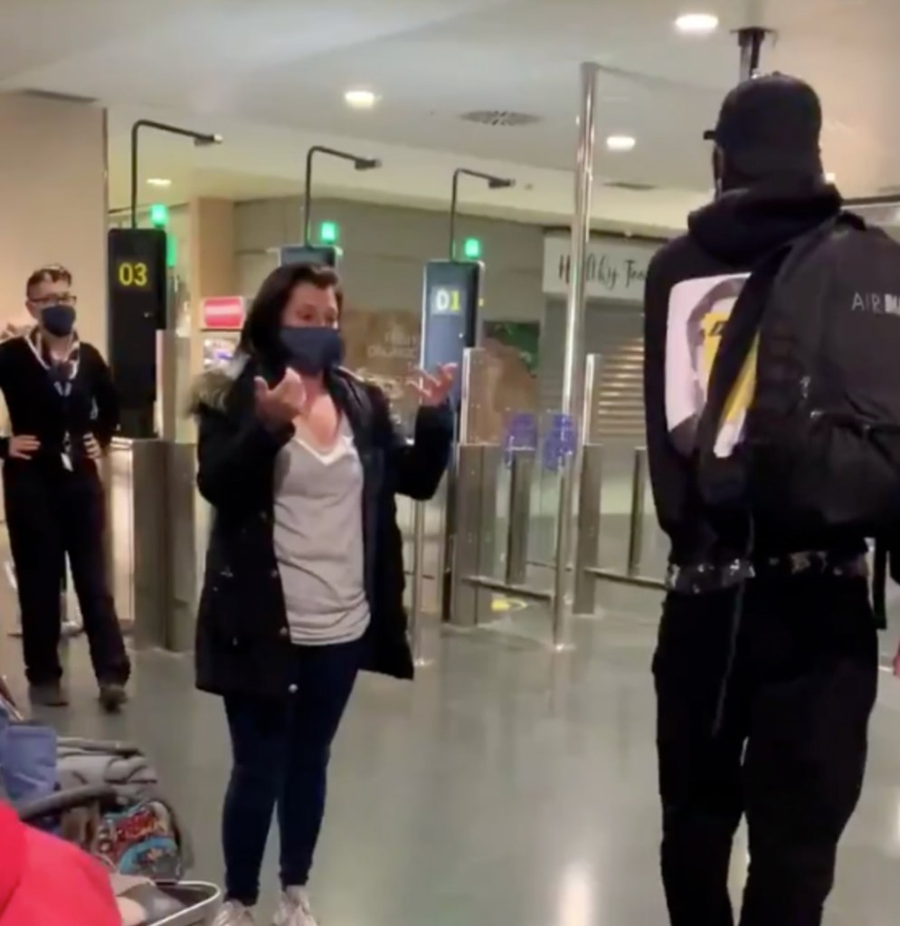 Eine Mutter bedankt sich bei einem fremden Mann am Check-In eines Flughafens.