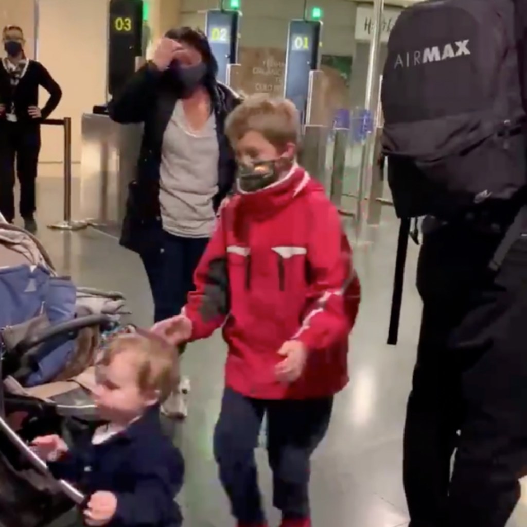 Eine Mutter mit Kind am Check-In eines Flughafens.