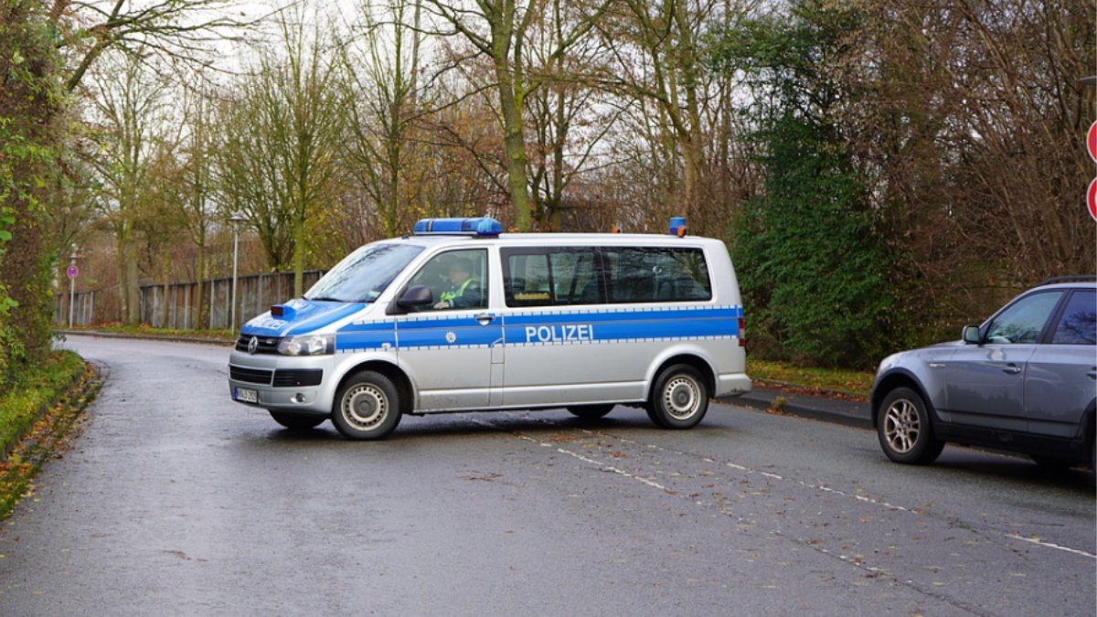 Ein Polizeiwagen versperrt eine Straße für eine Straßenkontrolle.