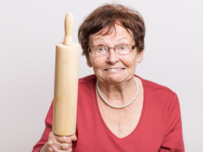 Ein Bild einer wütenden Rentnerin, die drohend ein Nudelholz in der Hand hält.