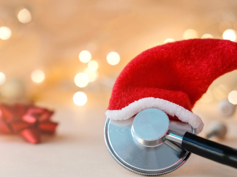 Ein Stethoskop mit einer kleinen Weihnachtsmütze.