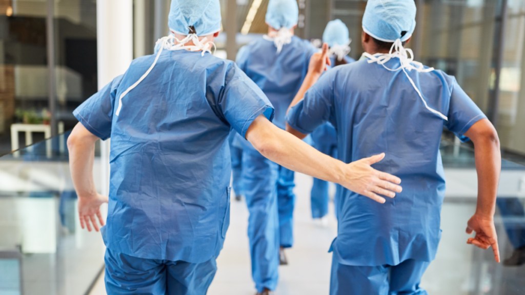 Vier Chirurgen laufen zu einem Notfall in einer Klinik.