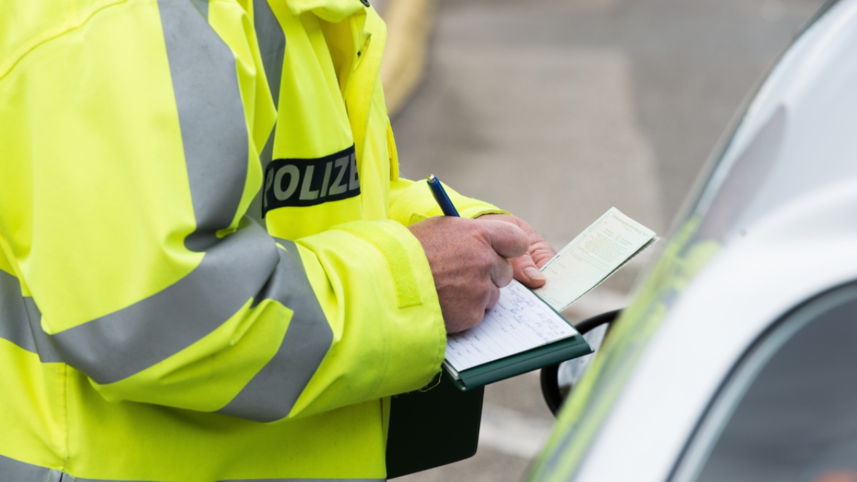 Ein Polizist schreibt ein Knöllchen.